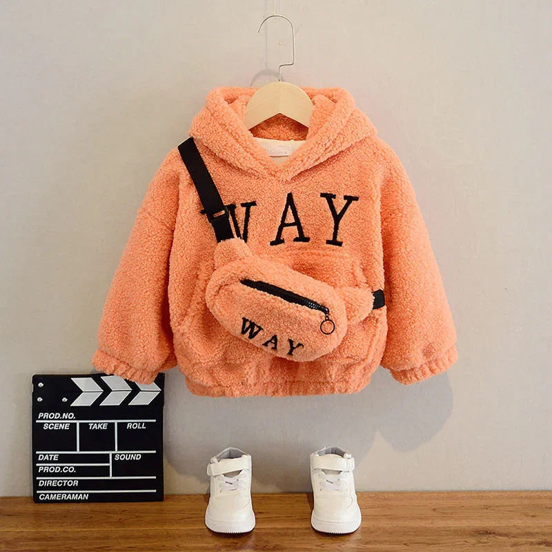 Peach fleece toddler hoodie with 'WAY' text, matching bag, white sneakers, and film clapperboard