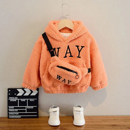 Peach fleece toddler hoodie with 'WAY' text, matching bag, white sneakers, and film clapperboard