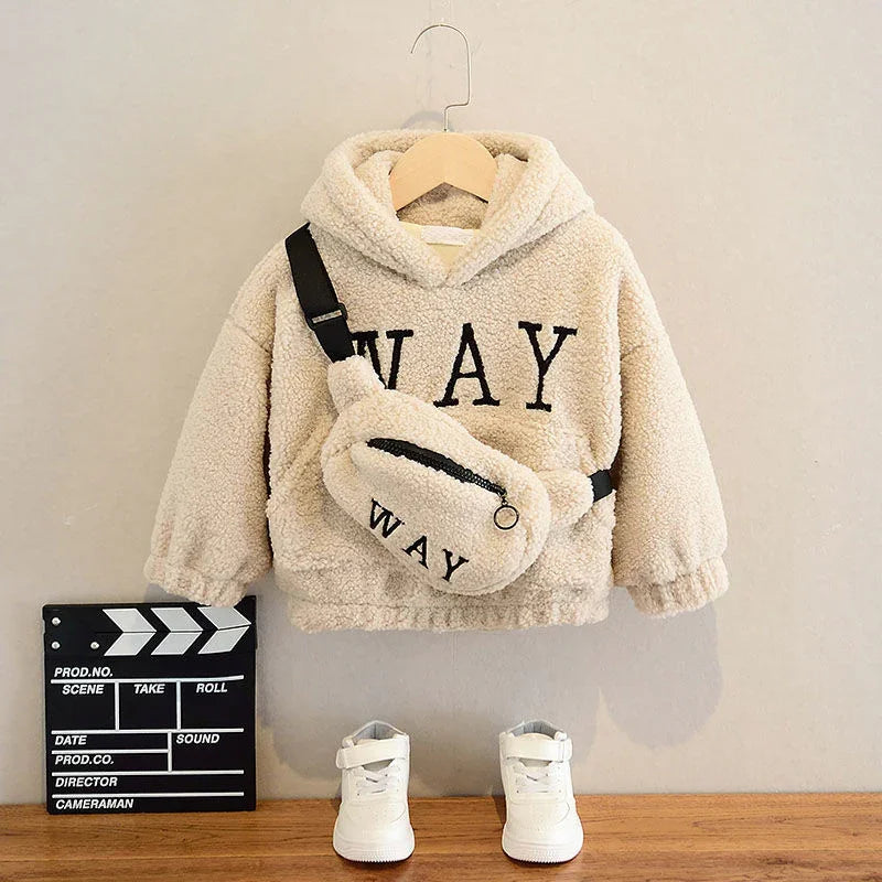 Kids cream fleece hoodie with WAY text, matching waist bag, white sneakers on wooden shelf