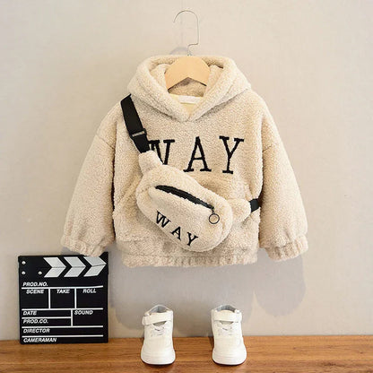 Kids cream fleece hoodie with WAY text, matching waist bag, white sneakers on wooden shelf
