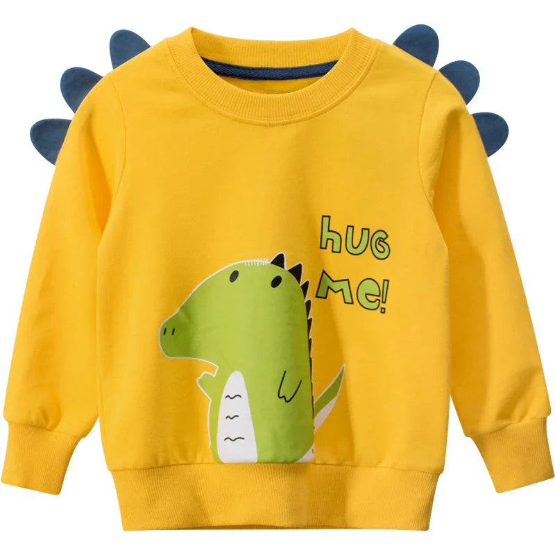 Yellow kids dinosaur sweatshirt with spikes and 'Hug Me!' text, cute cartoon design.