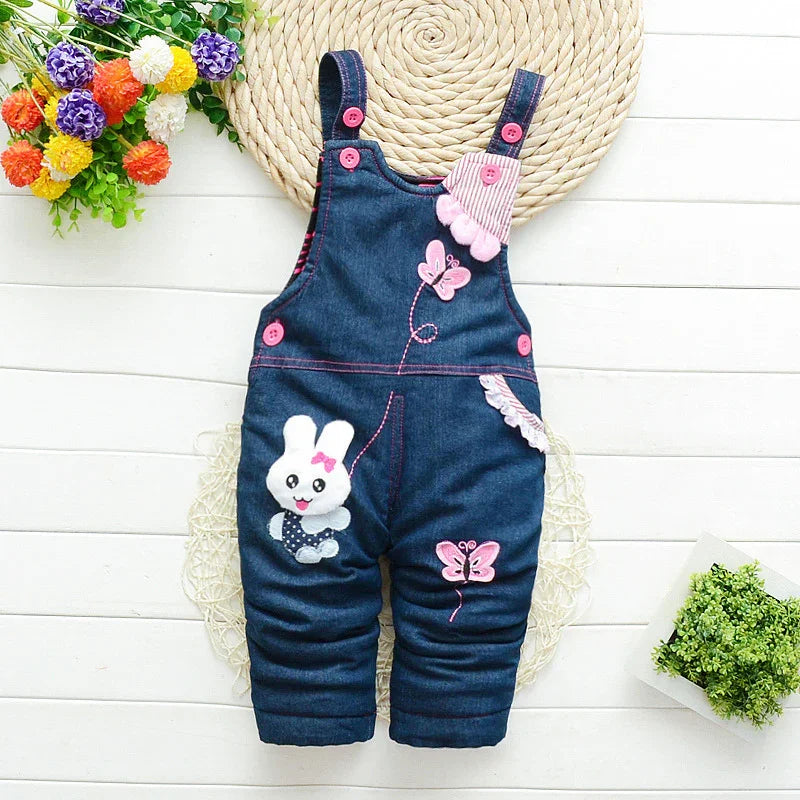 Denim baby overalls with bunny and butterfly appliques, floral decor, flat lay